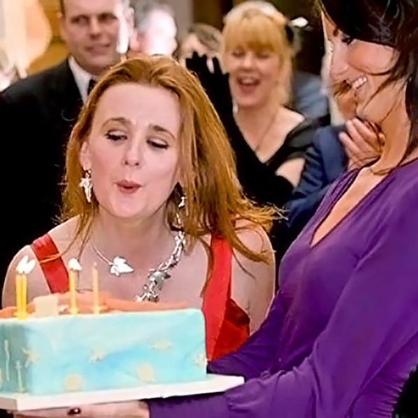 woman blowing out candles on birthday cake by event photographer in Glasgow, Scotland