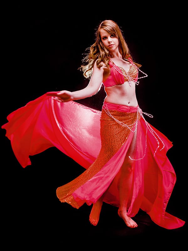 belly dancer in red costume spins with fabric floating