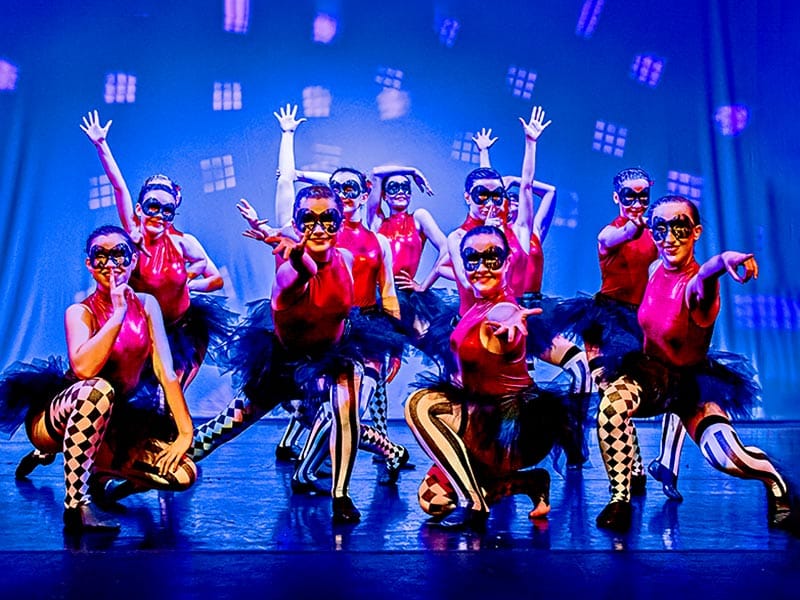 dancers in harlequin costumes onstage–dance show photography