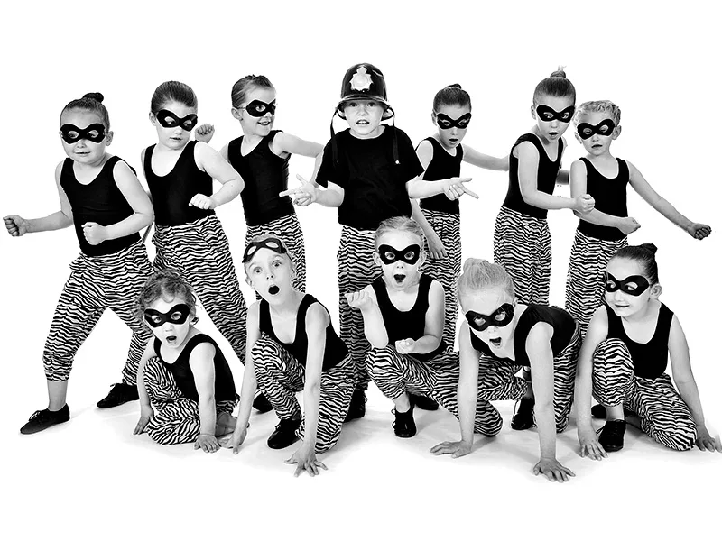 pre dance show photo call of kids in police and robber costumes in fun pose