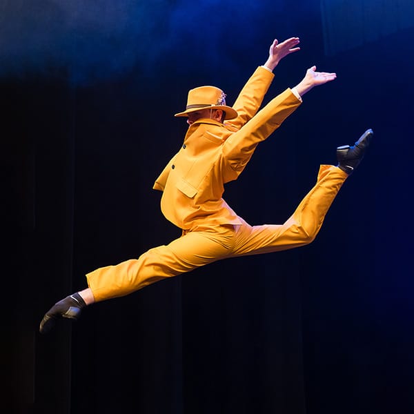 dancer-leaps-yellow-suit